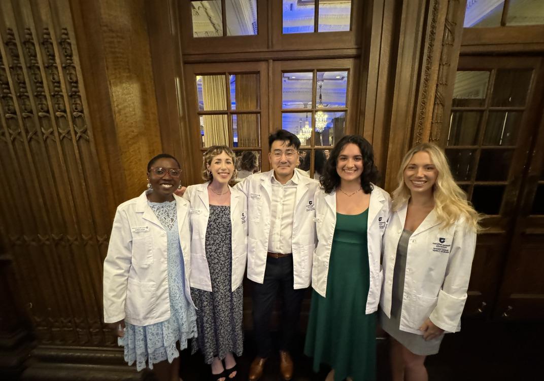 Group of smiling students wearing med student white coats